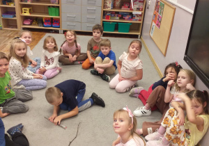 Zdjęcie przedstawia dziecko mierzące jeden z patyków.