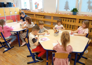 Dzieci z grupy Odkrywcy podczas kolorowania słodkich pączków.