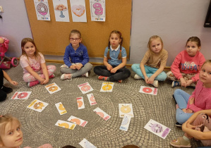 Dzieci z grupy Odkrywcy łączą w pary kolorowe pączki.