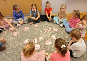 Dzieci z grupy Odkrywcy przeliczają oczka na pączkach i przyporządkowują im odpowiednią cyfrę.