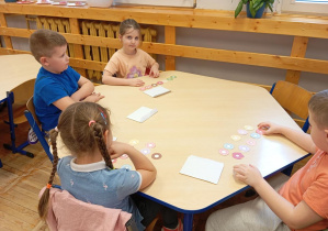 Dzieci z grupy Odkrywcy przeliczają i segregują pączki według odpowiednich cech.