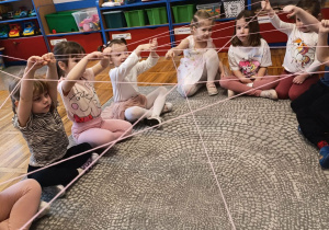 Dzieci z grupy Stokrotki podczas zabawy kłębkiem wełny.