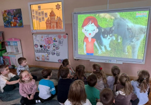 Smerfy oglądają film edukacyjny dotyczący rasów kotów, zasad ich pielęgnacji oraz ciekawostek.