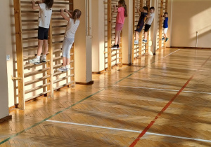 Dzieci ćwiczą na drabinkach.