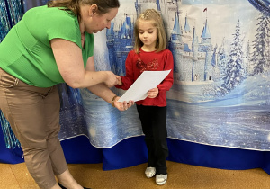 Dziewczynka z grupy Smerfy otrzymuje dyplom oraz nagrodę za zajęcie II miejsca.