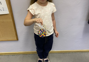 Druga wyróżniona dziewczynka pozuje ze swoją kolorową bombką.