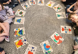 Zdjęcie przedstawia pokolorowane we folkowe wzory torebki wykonane przez dzieci.