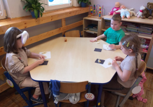 Zdjęcie przedstawia dzieci z własnoręcznie ulepionymi dinozaurami własnego pomysłu z masy solnej.