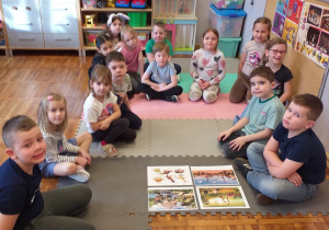 Zdjęcie przedstawia dzieci poznające różne dinozaury.