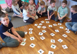 Zdjęcie przedstawia dziecko, które znalazło parę dinozaurów.