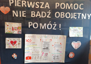 Napis pierwsza pomoc. Nie bądź obojętny. Pomóż! oraz prace wykonane przez dzieci.
