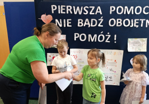 Pani wicedyrektor wręcza dyplom dziewczynce