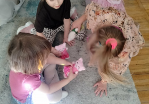 Dziewczynki oglądają swoje maskotki.