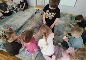 Chłopiec częstuje cukierkami.