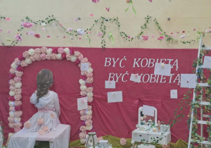 Dekoracja z napisem „Być kobietą, być kobietą”.