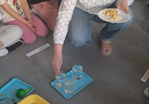 Pani wrzuca ziemniaki do szklanek wypełnione wodą słoną i słodką.