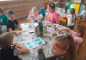 Dzieci pakują mydełko do pięknie przyozdobionych torebeczek.