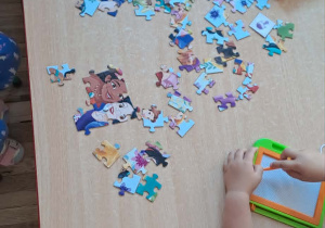 Na stoliku leżą puzzle, gdzie dzieci układają.