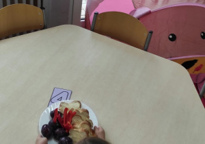 Dziewczynka przygotowuje łyżki i talerze.