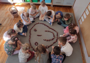 Dzieci z grupy Misie podczas kretywnych zabaw matematycznych z wykorzystanie kasztanów.