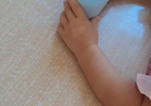 Na stoliku stoi kubek z sokiem jabłkowym.