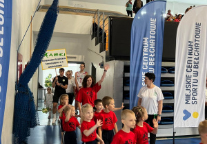 Drużyna macha do wszystkich krocząc po boisku hali podczas prezentacji drużyn.