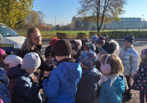 Dzieci otrzymują naklejki od Pani ze Straży Miejskiej