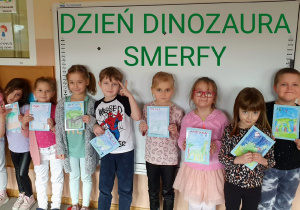 Zdjęcie grupowe, Smerfy prezentują wykonane przez siebie portrety dinozaurów.